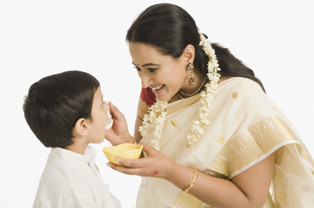 Woman feeding sweet to her son